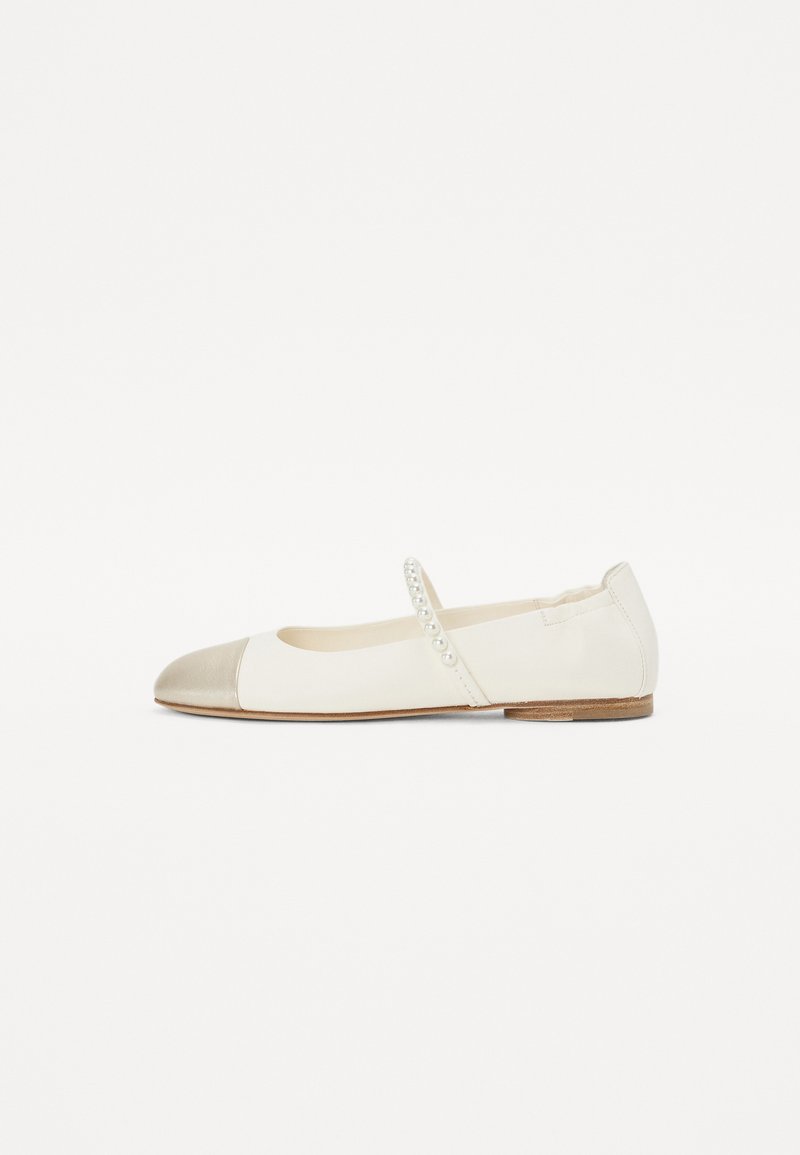 Ballerines en cuir blanc avec un bout en métal doré, une sangle élastique ornée de petites perles et une semelle en bois plate.