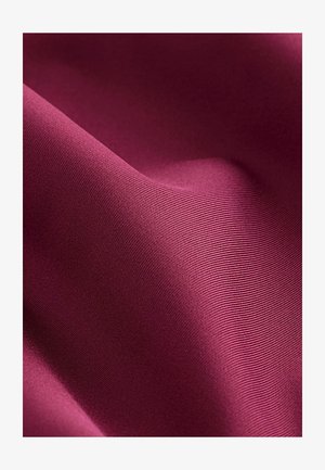 Bordeauxfarbener Stoff mit glatter Textur, der dezente Rippungen aufweist. Weich und lässt sich leicht drapieren, zeigt eine reiche, gleichmäßige Farbe.