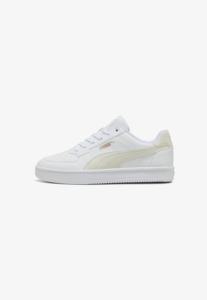 Fehér bőr sneaker krémszínű PUMA csíkkal, texturált felülettel, kerek orral, fűzős záródással és gumitalppal. Arany logó akcentus az oldalon.
