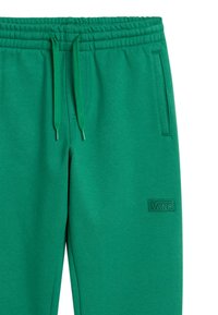 Groene joggingbroek van zachte stof, met een elastische tailleband, trekkoordsluiting, zijzakken en een geborduurd logo patch.