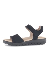 Zwarte sandalen met een brede teband, een verstelbare enkelband en een rubberen zool met textuur, voorzien van zigzagpatronen voor grip.