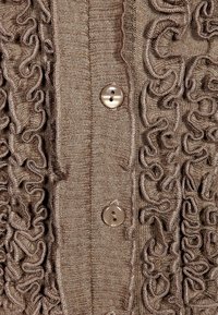 Brązowy kardigan z teksturowanymi falbanami z przodu, prążkowanym materiałem oraz dwoma okrągłymi guzikami do zapięcia.