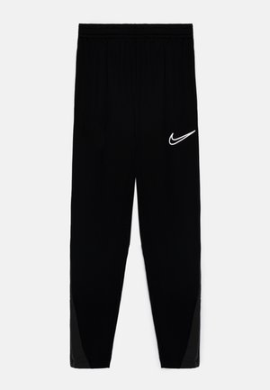 Black athletic pants with an elastic waistband, tapered design, and a white Nike logo on the left thigh. Includes mesh accents on the sides.