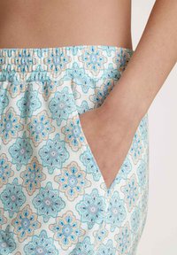 Lichte broek met een bloemenpatroon in blauw en beige, met een elastische tailleband en zijzakken voor extra functionaliteit.