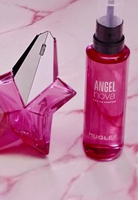 Bottiglia a forma di stella rosa con un tappo metallico e un beccuccio spray trasparente accanto a una alta bottiglia rosa etichettata "ANGEL nova Eau de Parfum" di Mugler.