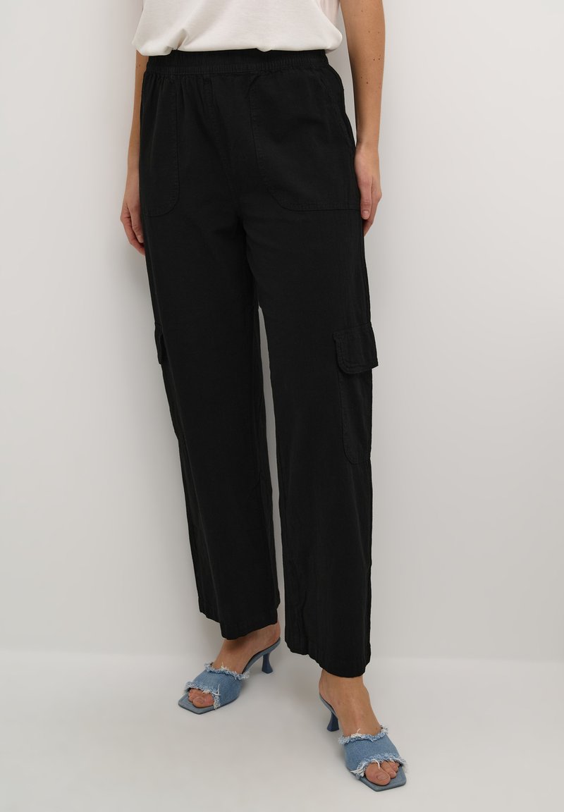 Zwarte cargobroek met een elastische tailleband, zijzakken, een losse pasvorm en een textiele stof. Gecombineerd met denim hakken.