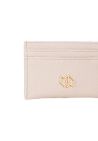 Porta carte in pelle beige con quattro slot per carte, logo in rilievo in metallo dorato, superficie testurizzata, forma rettangolare compatta.