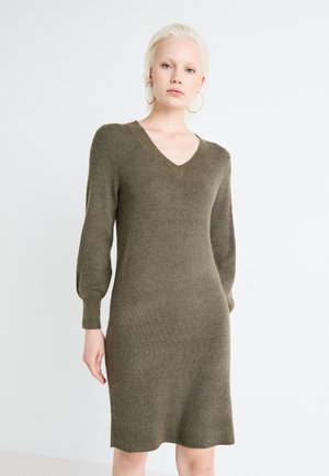Olivevihreä, ribbed neulemekko V-päällä ja pitkät puff-hihat. Keskipitkä malli, pehmeä rakenne, tiukka siluetti ja ei näkyvää metalliosaa.