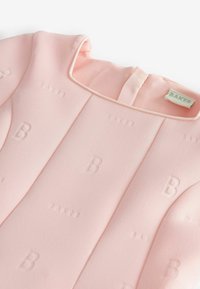 Helles rosa Kleid mit geprägtem "BAKER"-Branding und weicher Textur. Rundhalsausschnitt und Rückenschluss mit einem Ribbonsdetail.