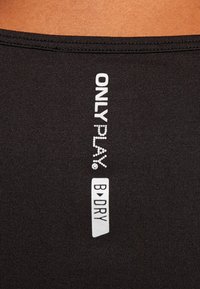 Svarta träningsshorts med en slät textur, med vit "ONLY PLAY" text och en "B:D.RY" etikett nära midjan.