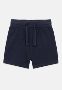 Shorts en coton bleu marine avec une ceinture élastique et un cordon de serrage. Présentent une texture lisse et des bords ourlés, conçus pour le confort.
