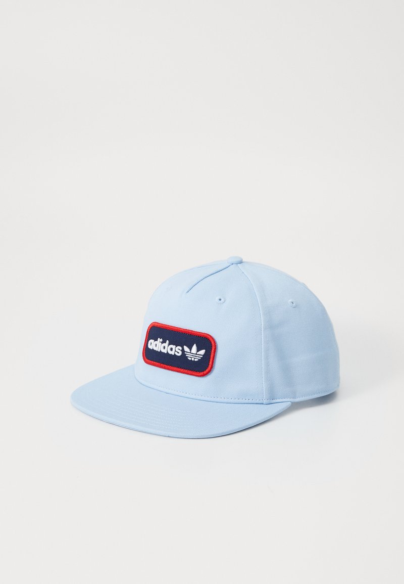Casquette en coton bleu avec une visière plate, ornée d'une patch rectangulaire bleu marine avec une bordure rouge affichant le logo "adidas" et l'emblème trèfle.