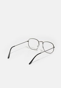 Ochelari subțiri din metal cu un design geometric. Ramă gri închis, lentile dreptunghiulare și capete de brad din plastic negru. Accentuati cu suporturi pentru nas.