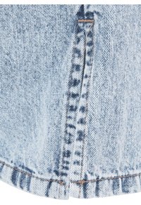 Primo piano di tessuto di denim celeste con cucitura verticale e motivo sbiadito di lavaggio blu scuro vicino al bordo dell'orlo.