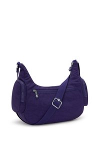 Bolso de hombro de tela morada con dos bolsillos laterales con cremallera, correa ajustable, forma curvada y textura suave. Diseño ligero.
