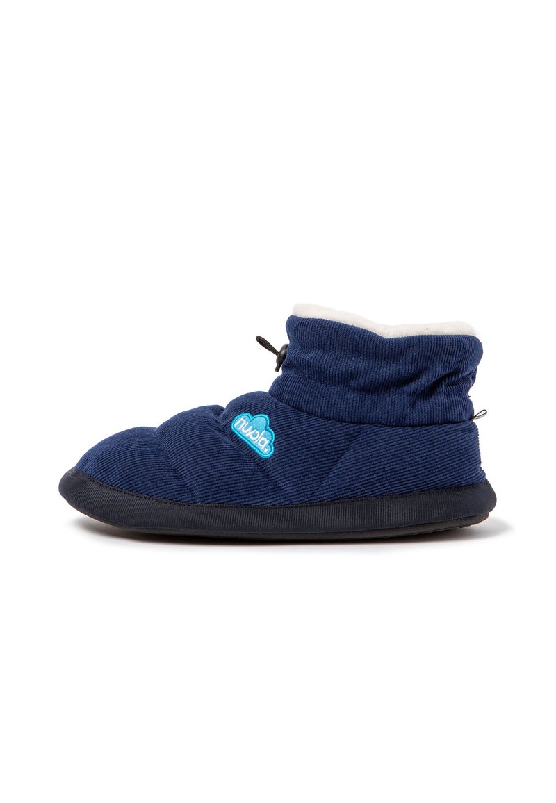 Zapatilla acolchada de color azul marino con un suave forro blanco, punta redondeada, suela de goma negra y un acento de logo azul, con un diseño plegable.