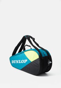 Dunlop Sporttasche mit schwarzem Grundton, blauen und neon-grünen Akzenten, ergonomischen Trägern und einem schlanken Design mit prominentem Logo.