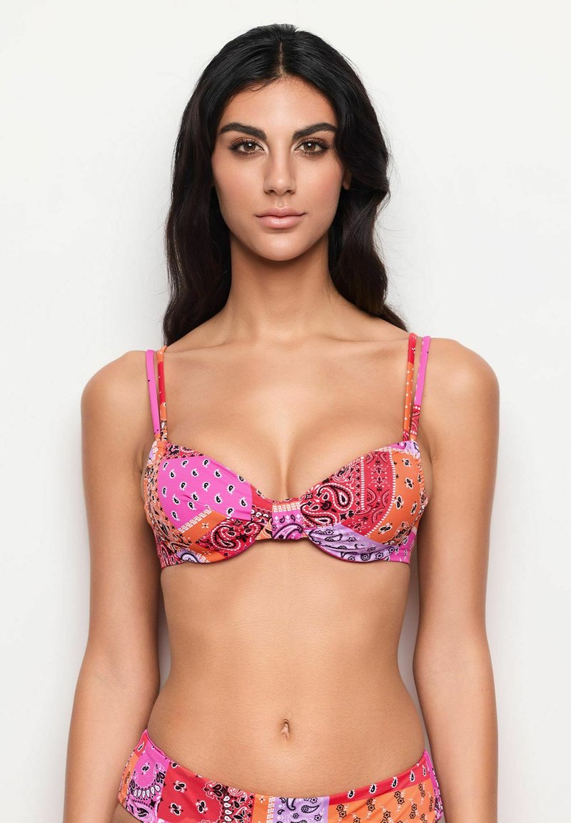 Bra made of colorful patterned fabric in shades of pink, orange, and purple, with a twist front design and thin adjustable straps.