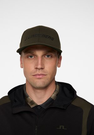 Grøn baseballcap med et struktureret design, der har et sort logo "J. Lindeberg" præget på fronten, sat mod en ensfarvet baggrund.