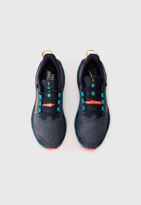 Baskets de course navy avec une tige en maille texturée, des accents orange et des lacets turquoise. Présente une semelle rembourrée et une languette au talon.