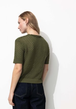 Pull en tricot de couleur vert olive avec un motif géométrique en mailles ouvertes, col rond et manches courtes avec des bords-côtes aux poignets et à l'ourlet.