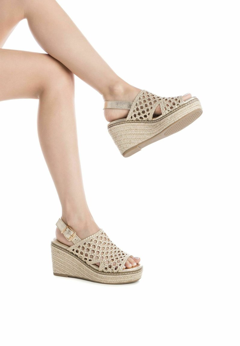 Sandalias de cuña beige con punta abierta y textura trenzada. Con correa tipo slingback y suela de goma texturizada para mayor agarre.