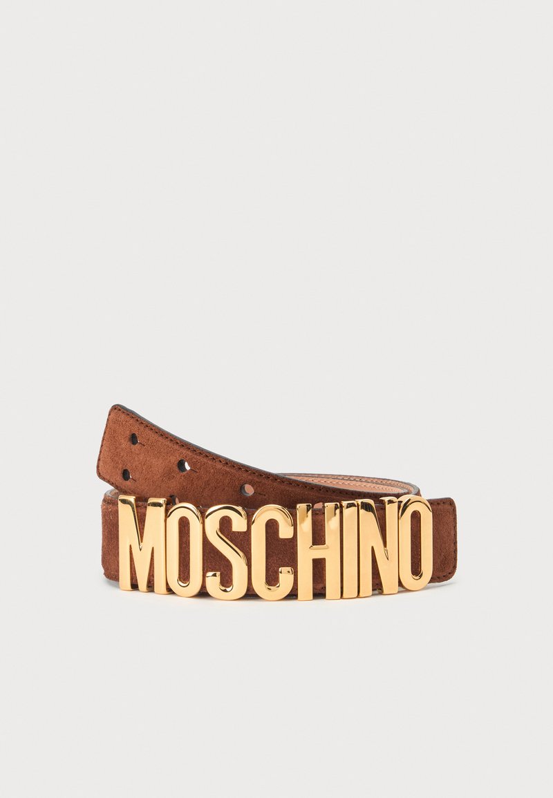 Ceinture en daim marron avec de grandes lettres dorées formant MOSCHINO comme boucle, présentée sur un fond clair uni.