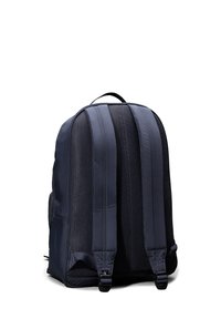 Zaino navy con schienale imbottito in rete, spallacci regolabili e maniglia superiore. Presenta un tessuto liscio con dettagli del logo e scomparti con zip.