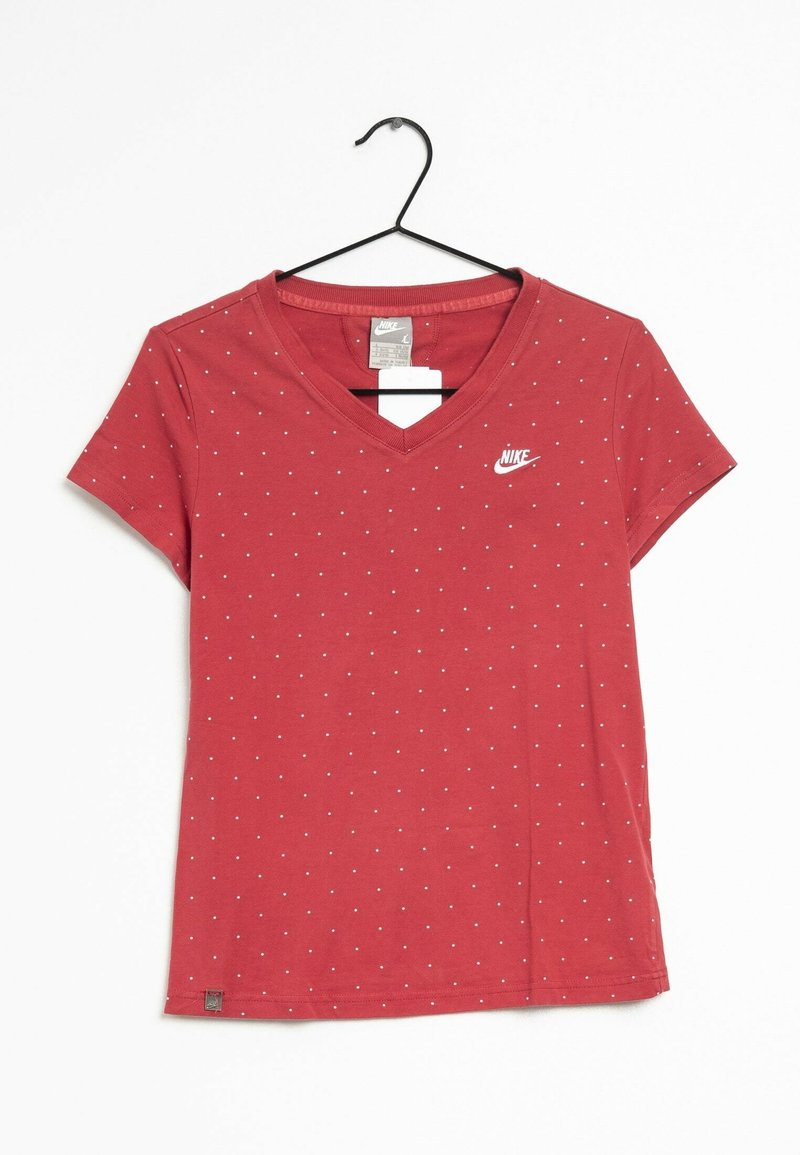 Röd bomulls T-shirt med V-hals, korta ärmar, vita prickar och en vit Nike-logga på vänster bröst. Hänger från en svart krok.