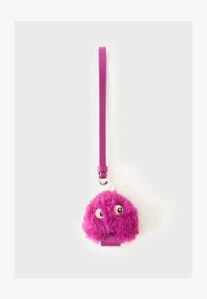Llavero peludo morado con dos ojos móviles, unido a una larga correa morada sobre un fondo blanco.