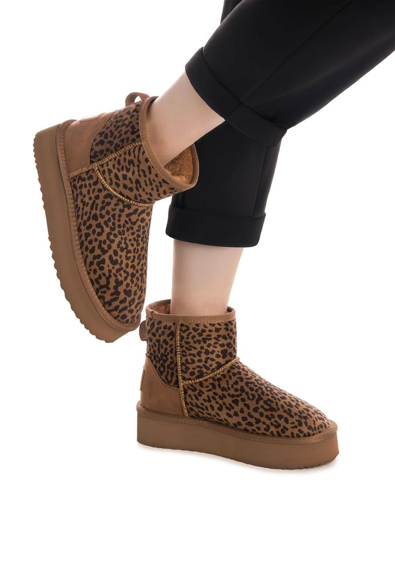 Braune Stiefeletten aus Wildleder und Fell mit Leopardenmuster. Runde Zehen, klobige Sohle und dekorative Nähte entlang der Nähte.