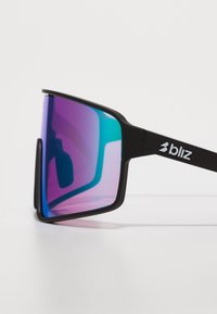 Des lunettes de soleil avec une monture noire et de grandes lentilles rectangulaires présentant un dégradé de violet à teal, agrémentées d'un logo blanc sur le côté.
