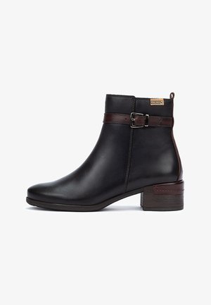 Bottine en cuir noir avec une forme effilée, une sangle en cuir marron et un détail de boucle, ainsi qu'un talon en bois empilé. Texture lisse sur l'ensemble.