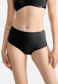 Culotte noire taille haute en tissu lisse, avec un design simple, des bords élastiques et un branding minimal.