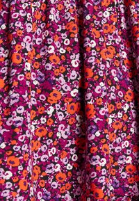 Květinová látka s malými fialovými, bílými a oranžovými květy na tmavém pozadí. Lehká textura se skládáním.