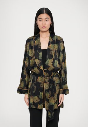 Crni kimono-izgled kaput s uzorkom zelenih i narančastih listova, koji ima duge rukave, pojas i kontrastne obrube duž rubova.