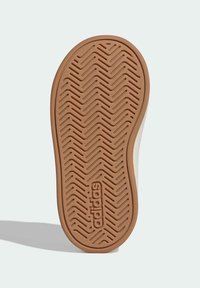 Đon obuće s smeđim gumiranim materijalom, s uzorkom ureza u cik-cak i utisnutim logotipom "adidas", zaobljenog oblika, ravne površine.