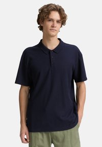 Marineblaue Kurzarm-Polohemd aus strukturiertem Stoff, mit Knopfleiste und klassischem Kragen.