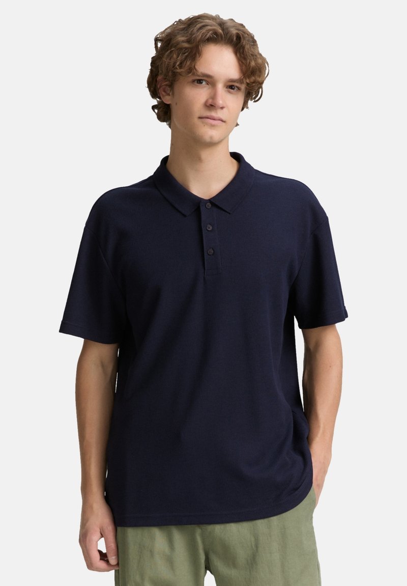 Marineblaue Kurzarm-Polohemd aus strukturiertem Stoff, mit Knopfleiste und klassischem Kragen.