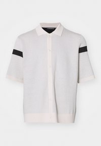 Polo shirt bianco a maniche corte in maglia con chiusura a bottoni, caratterizzato da un motivo testurizzato e una striscia nera solida su ciascun manica.