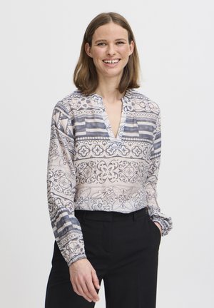 Halenka s dlouhým rukávem vyrobená z lehké látky, zdobená modro-krémovým paisley a geometrickým vzorem, s výstřihem do V a manžetami.