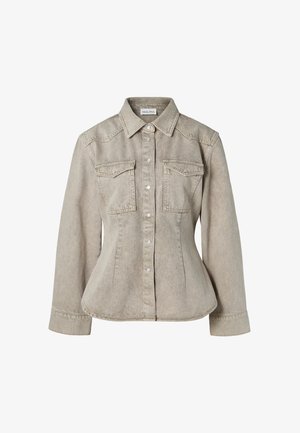 Chemise en denim beige avec une taille cintrée, col classique, deux poches poitrine et boutons-pression en argent. Tissu texturé et manches longues.