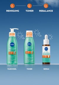 NIVEA Derma Skin Clear Set: grüner Gelreiniger mit Pumpe, verfeinernder Toner mit weißem Deckel und braunem Serum in einer Pipettenflasche. Arial-Textetiketten enthalten.