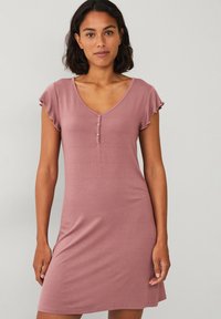Korte roze jurk met een V-hals, kapmouwen met geribbelde randen en drie knopen aan de voorkant. Gemaakt van zachte stof in een aansluitend ontwerp.