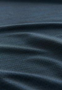 Tejido suave y texturizado en un profundo color azul marino con finas rayas horizontales, creando una apariencia lisa y uniforme.