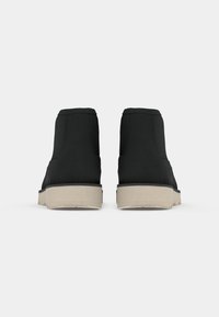 Black ankle boots featuring a smooth fabric upper, a light beige rubber sole, and a simple design without visible hardware or patterns.