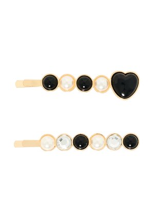 Guldtonede hårklips med et sort hjerte og skiftende sorte, hvide og klare runde sten. Glatte overflader med skinnende detaljer.
