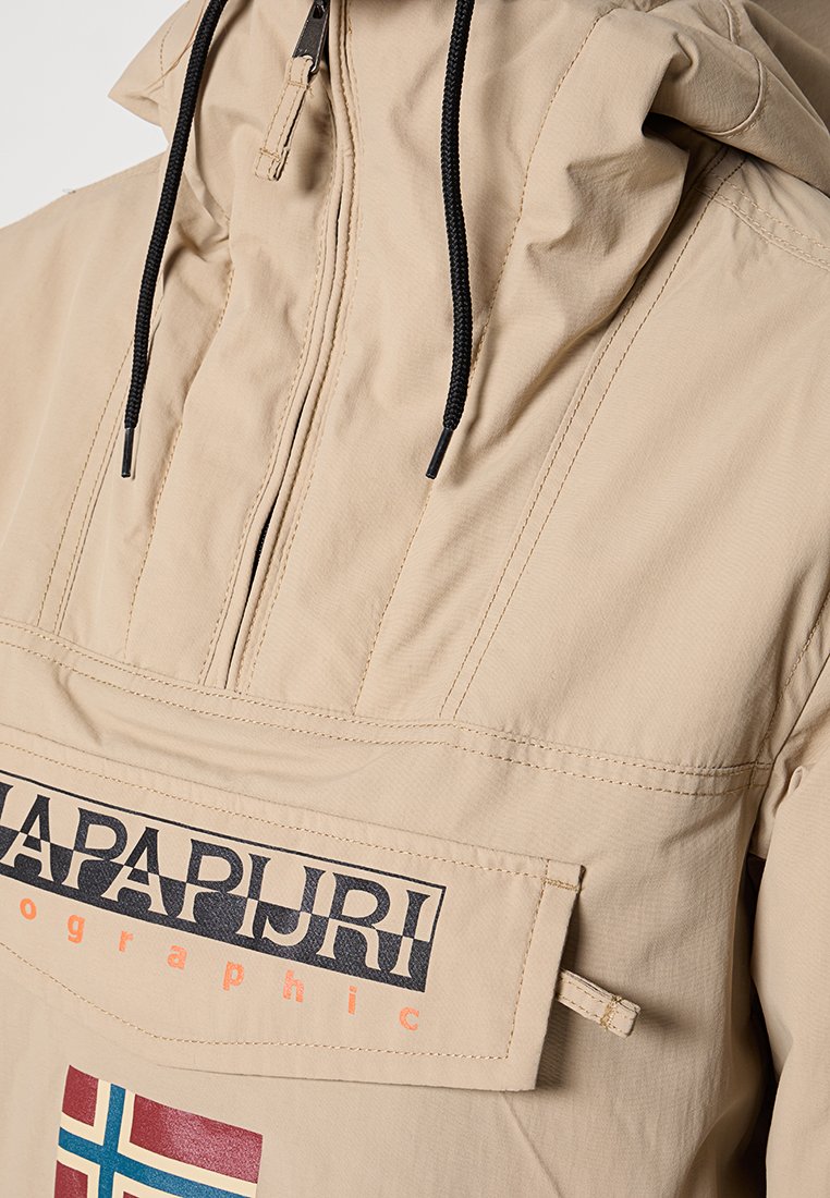 Beige pulloversjack met een capuchon, voorzien van een voorzak, zwarte koorden en een logo-opdruk met een accent van de Noorse vlag.