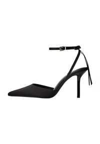 Fekete, hegyes orrú magassarkú cipő szaténszerű anyagból, bokapánttal és csattal, vékony tűsarkú. Minimalista kialakítás.