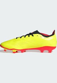 Scarpini da calcio giallo lime con lacci neri, tomaia testurizzata e suola rossa. Presentano un collo aderente e linee di design nette sulla superficie.